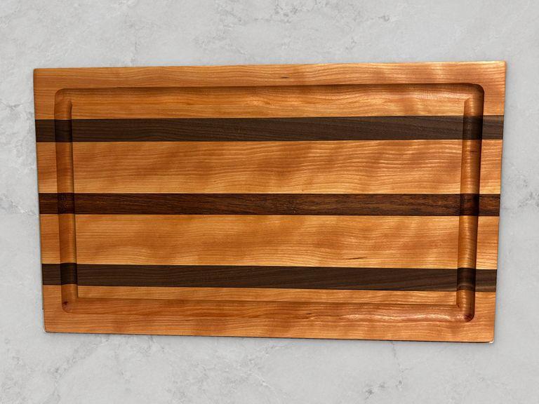 Cherry edge-grain cutting board with walnut stripes