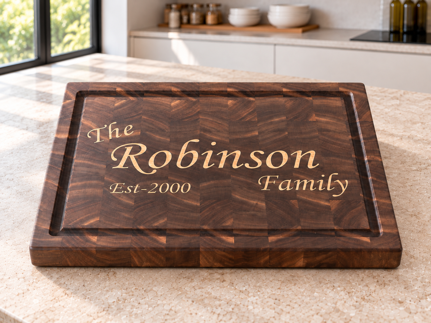 Personalized walnut end-grain family board with a maple inlay reading The Robinson Family, Est 2000, on a kitchen counter